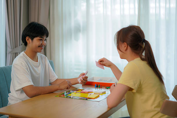 istock Two Friends Enjoying Monopoly game at Home 2205718042