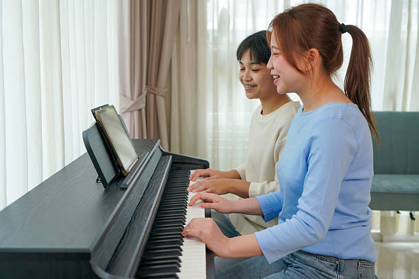 istock Two Friends Practicing Piano Together at Home 2205718332
