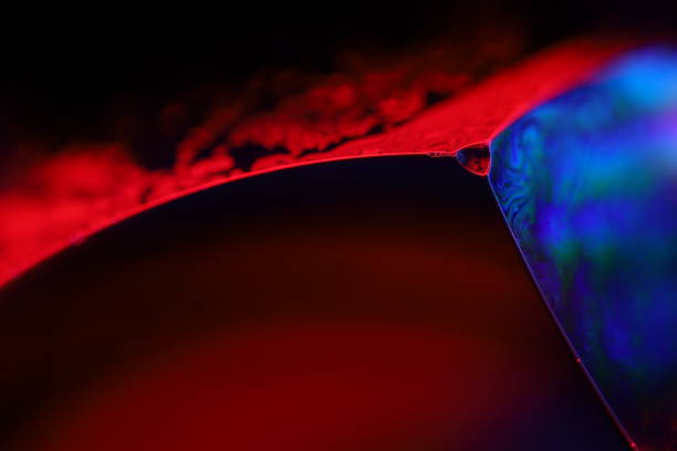 istock Red and purple liquid reflections on dark background, futuristic abstractions 2205720251