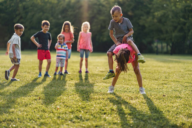 istock Happy children having fun while playing leapfrog game in public park 2205722870