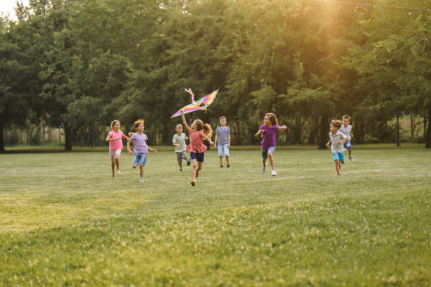 istock Children run with a kite during summer day in the park 2205723664