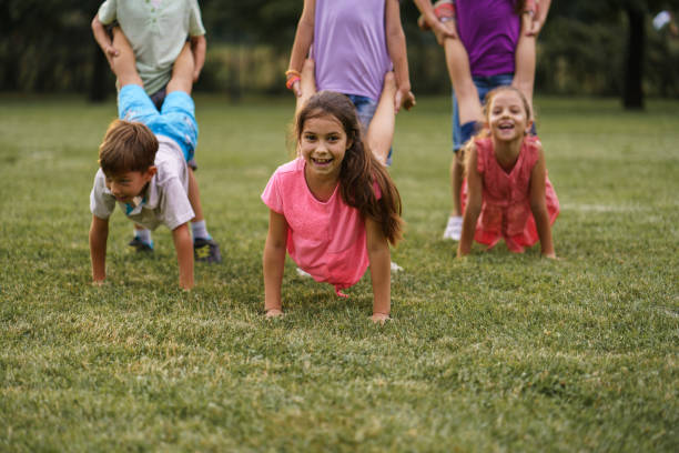 istock Children playing wheelbarrow race in public park 2205724199
