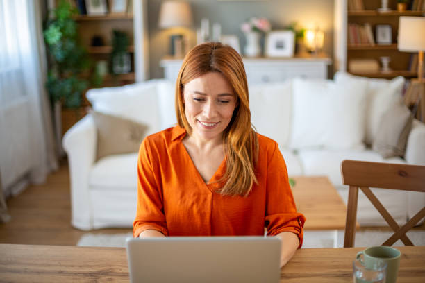 istock Front view of smiling woman working on laptop 2205727647