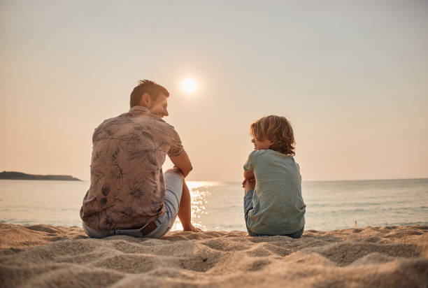 istock Father and son enjoying sun on the beach 2205728408