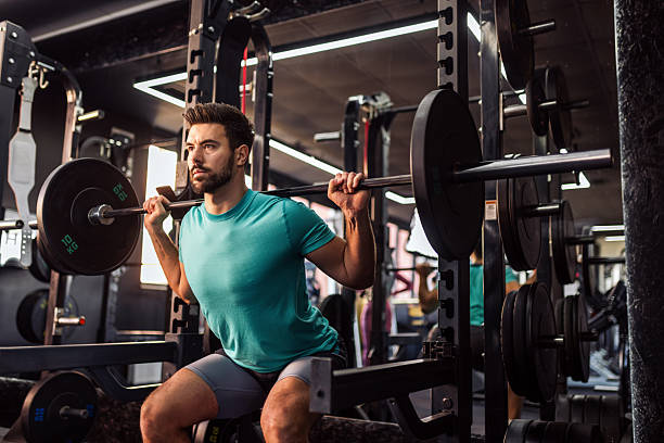istock Athletic man does barbell squats in the gym. 2205730563