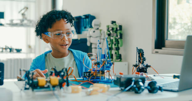 istock Young African-American boy in STEM education by assembling robot at home. STEM Education robotics courses online. 2205736389