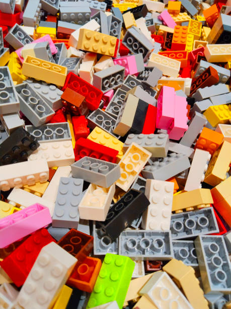 istock Patterns of brightly colored plastic toy blocks including yellow, pink, red, white, blue and grey. 2205737107