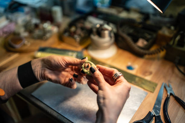 istock Hands Holding Jewelry Product in Workshop Setting with Tools Nearby 2205737767