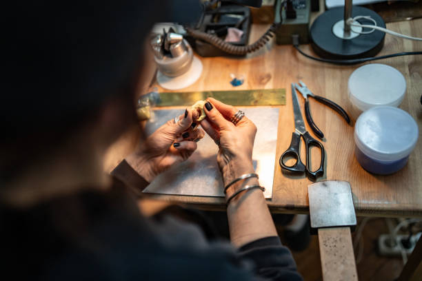 istock Craftsman Working on Jewelry Piece at Organized Workshop Table 2205737780