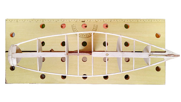 HIgh angle view of handcrafted wooden model of a sailboat under construction.
