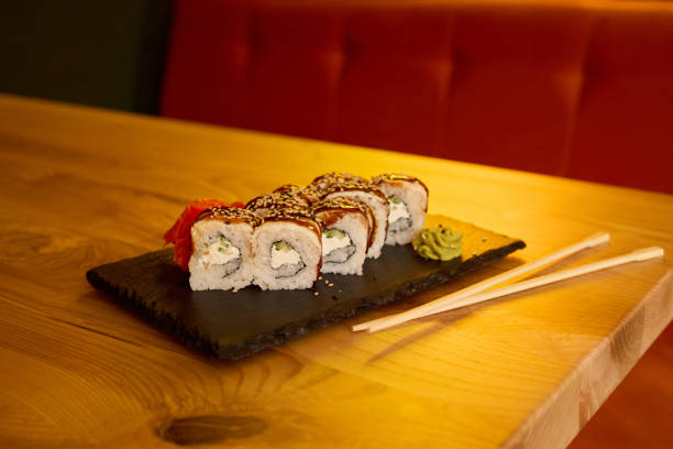 istock Delicious sushi rolls are arranged neatly on a slate plate, featuring fresh ingredients and garnished with wasabi and pickled ginger, creating an inviting dining experience 2205742399