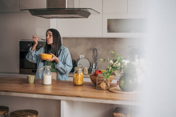 istock Young woman enjoying a healthy breakfast in her modern kitchen 2205746102