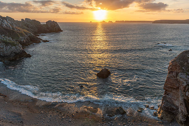 istock Pointe de Dinan. The ocean is calm and the sun is setting, creating a beautiful 2205747187