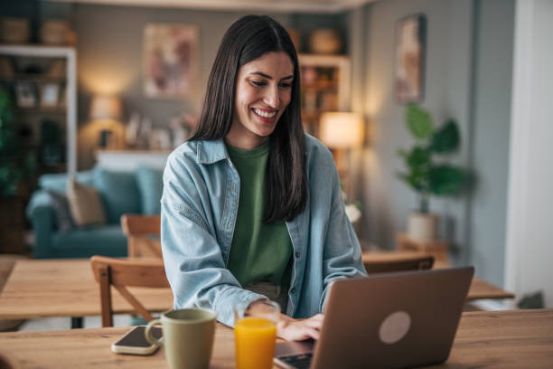 istock Young woman working from home on laptop and smiling 2205748694