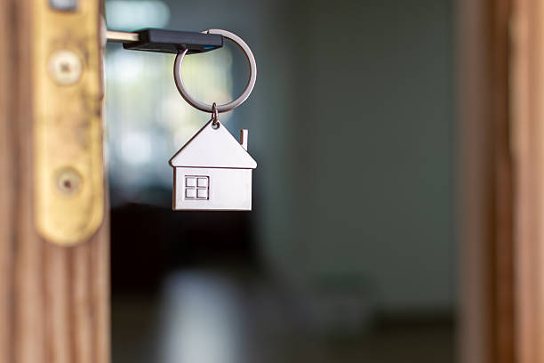 istock A houseshaped keychain hangs on a door with a key 2205750097