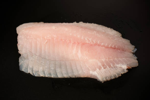 istock Fresh tilapia fillet on black background, top view. 2205755571