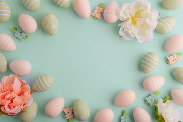 istock Pastel easter eggs and flowers on green background. Top view 2205756354