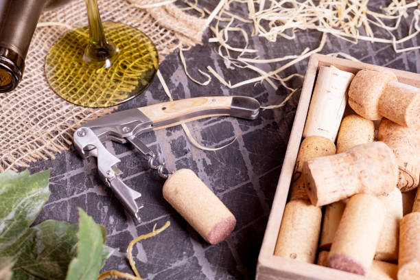 istock corkscrew, a cork and a bottle of wine on an old black table in the cellar. 2205760441