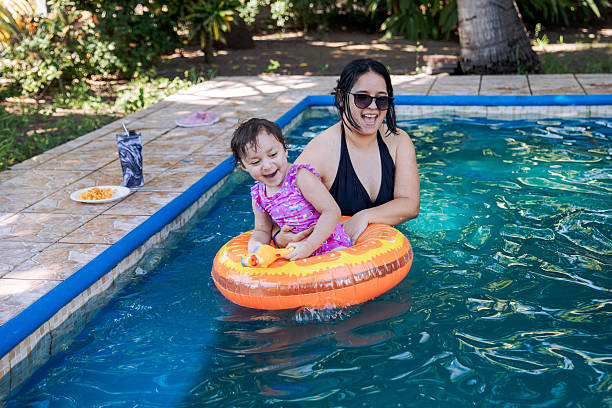 Carefree little girl with water wings having fun with her single mother during summer day in the sea. Copy space. Photographed in medium format.