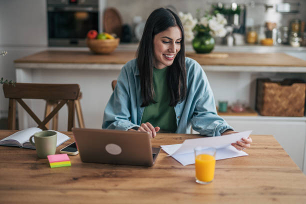 istock Young woman working from home managing finances and bills 2205765969