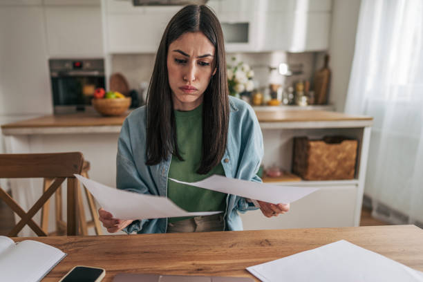 istock Stressed young woman reading documents at home 2205766064