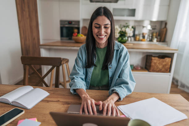 istock Young woman working from home on laptop and smiling 2205766081