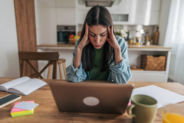istock Stressed young woman working from home having headache 2205766231