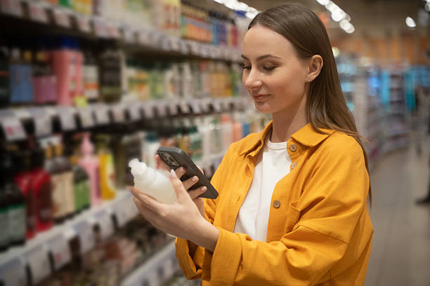 Shower gel scanning in store by a customer while comparing options and checking information on phone stock photo