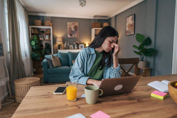 istock Young woman suffering from headache while working from home 2205766558