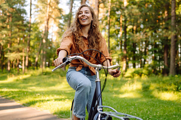 istock Young modern woman rides bicycle in the park. 2205766677