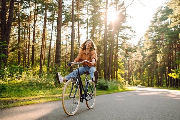 Young modern woman rides bicycle in the park.