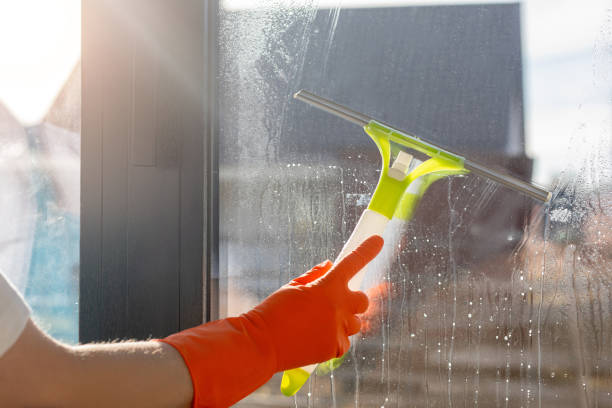 istock A cleaning lady cleans a window with a scraper. 2205766700