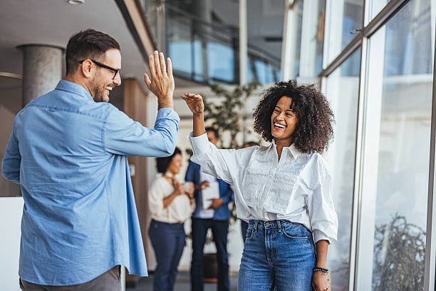 istock Office Colleagues Celebrating Success With High Five In a Modern Workplace 2205768081