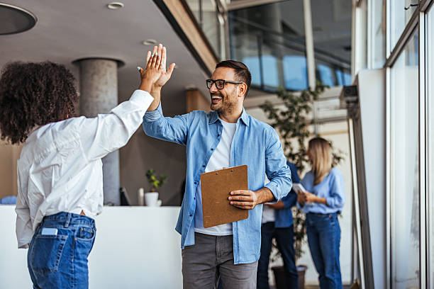 istock Coworkers Celebrating Success With High Five In Modern Office Environment 2205768160