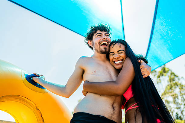 istock Friends embracing while waiting to go on a water park slide 2205769440