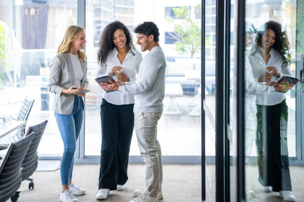 istock Three business people talking meeting while standing in the office 2205770667