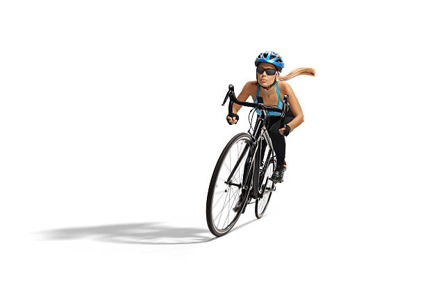 Female cyclist riding a bicycle fast isolated on white background