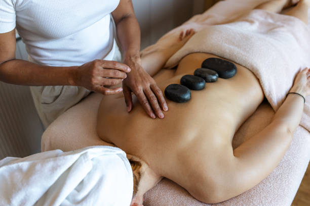 istock Woman receiving Therapeutic Stone Massage at a spa 2205771175