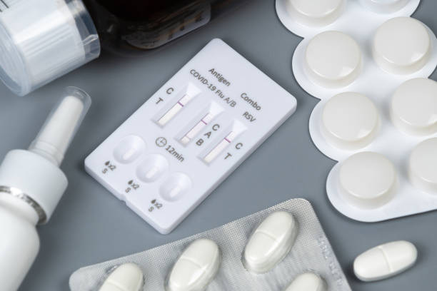 istock Flu test, pills, cough syrup, nasal spray and tissues on gray background. 2205772731