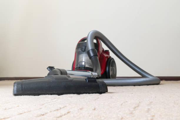vacuum cleaner without a bag of blue color stands on the floor of the house background