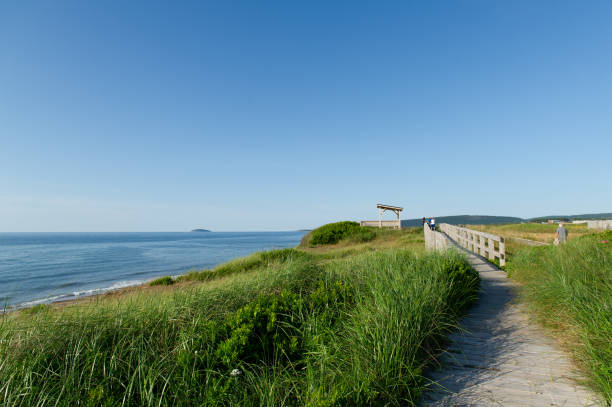 Visitors stroll along the Inverness boardwalk, enjoying coastal views.