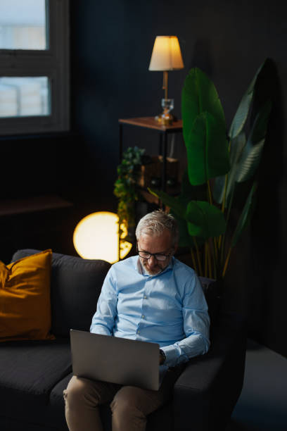 istock Focused mature businessman working late on laptop at home office 2205776848
