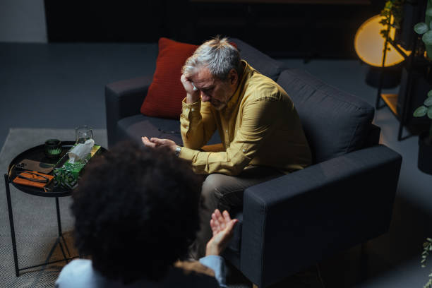 istock Depressed mature man talking with psychologist on therapy session 2205776857