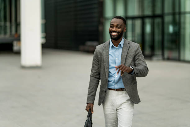 istock Smiling black businessman walking from work outdoors. 2205776860