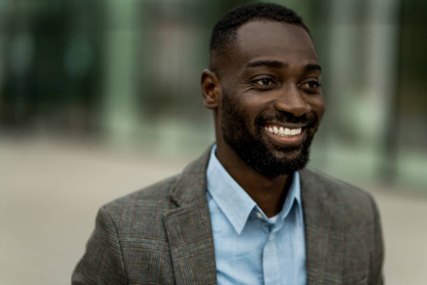 istock Smiling black businessman walking from work outdoors. 2205776900
