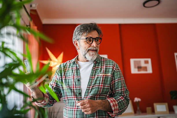istock mature bearded man have fun while use mobile phone in the living room 2205777017