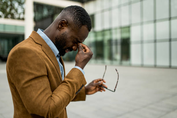 istock Tired black businessman having eyesight problems outdoors. 2205777193