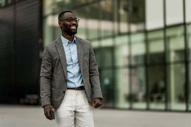 istock Smiling black businessman walking from work outdoors. 2205777320