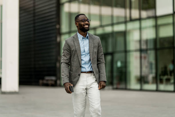 istock Smiling black businessman walking from work outdoors. 2205777337