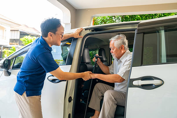 istock Caregiver helping senior man get in the car. 2205778004